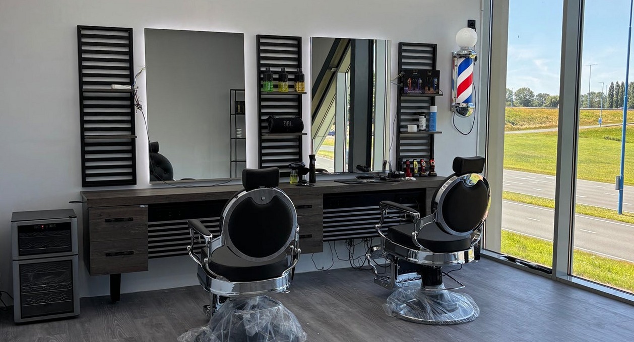 De twee stoelen voor de spiegelwand, met rechts de barberpaal en de ramen